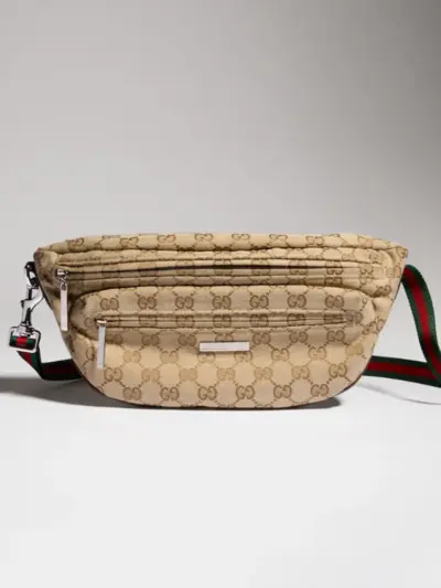 Gucci Tag small crossbody fanny pack in GG canvas, adjustable red and green web strap, multi front zipper pockets and brand themed metal zipper charm