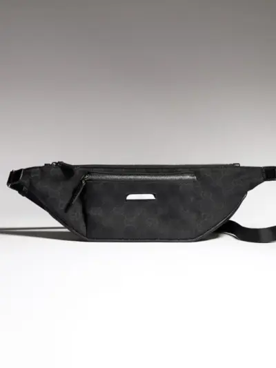 Gucci Flatpack small belt bag in black GG canvas, matching adjustable fabric strap, front zipper pocket and silver metal brand name plate